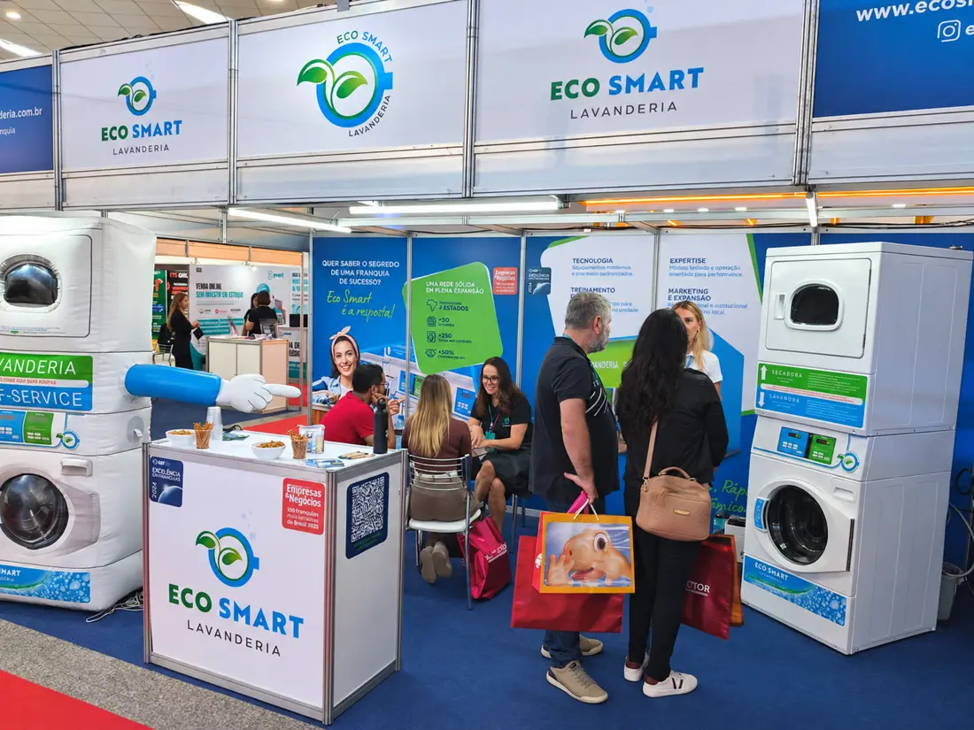 Visitantes no estande da Eco Smart Lavanderia, com lavadora e secadora em operação, na Feira da Franquia de Curitiba