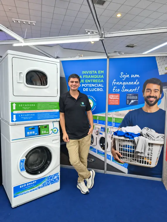 Leandro Azevedo, fundador da Eco Smart Franchising, ao lado da lavanderia em operação no estande