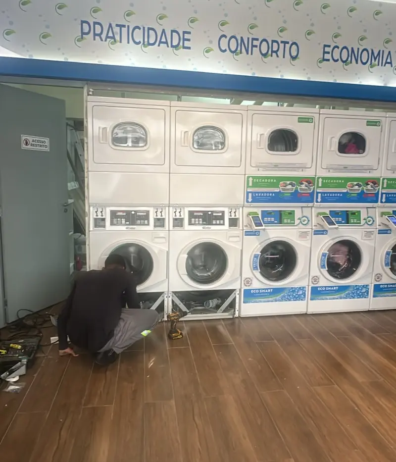 Técnico instalando os novos conjuntos de lavadora e secadora na Eco Smart Lavanderia do Méier