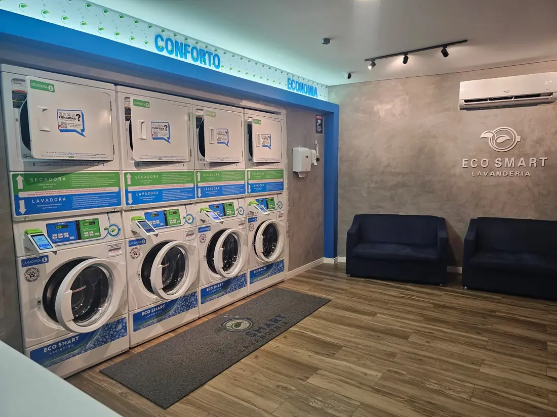 Interior amplo da Eco Smart Lavanderia, lavanderia self-service em Valinhos/SP, com 4 lavadoras, 4 secadoras e sofás